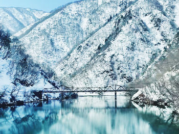 Scenic view of lake by snowcapped mountains during winter in shirakawa-go