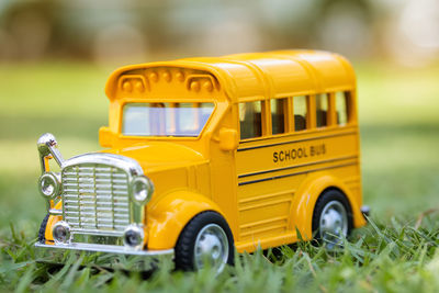 Close-up of yellow toy car on field