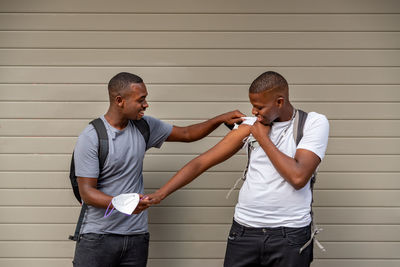 Afro men friends vaccinated showing his arm