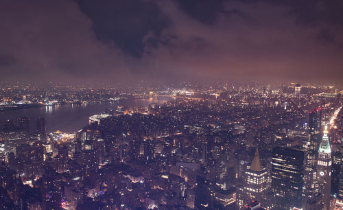 High angle view of illuminated cityscape against sky at night