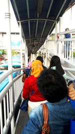 Rear view of people standing on bridge