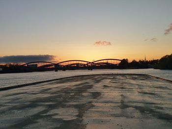 Bridge over river against sky during sunset