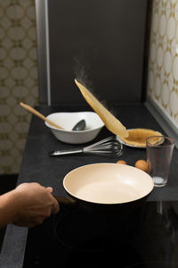 Cropped hand of person preparing food on table