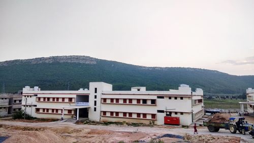 Buildings against mountain range against clear sky