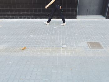 Low section of woman standing on tiled floor