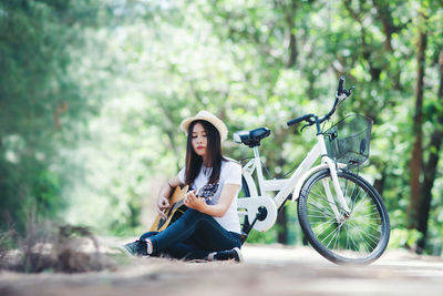 Full length portrait of woman sitting on bicycle