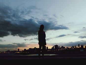 Silhouette person with ball in background against sky