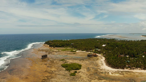 Aerial view of wooden walkway for surfers to cross the reef of siargao island to cloud 9 surfspot. 