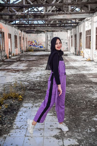 Portrait of smiling girl standing against building