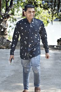 Portrait of young man wearing sunglasses standing outdoors