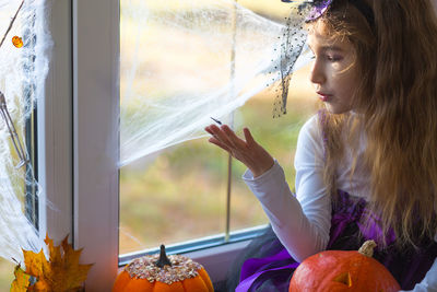 Young woman looking through window