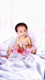 Cute baby girl sitting on bed