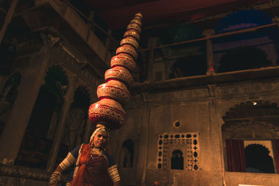 A woman carrying pots on her head and dancing