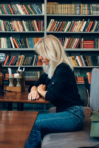 Woman sitting on book at table