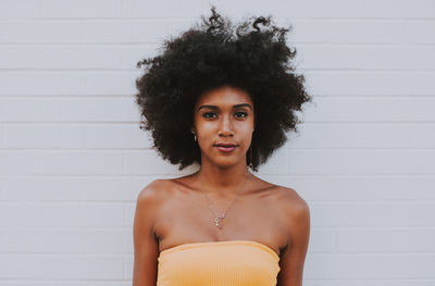 Portrait of woman standing against wall