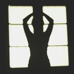 Shadow of person hand on window