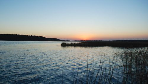 Scenic view of calm lake at sunset