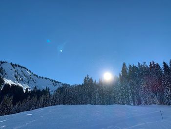 Scenic view of snow covered landscape against blue sky