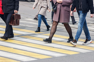 Low section of people walking on road