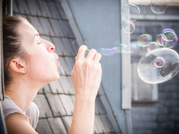 Close-up of young woman holding bubbles
