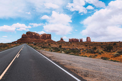 Road passing through against cloudy sky