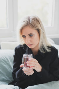 Young woman drinking coffee at home