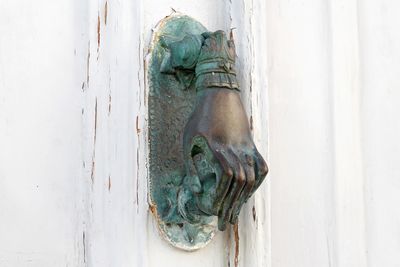 Close-up of old statue against wall