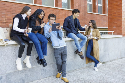 Young friends talking in front of university college