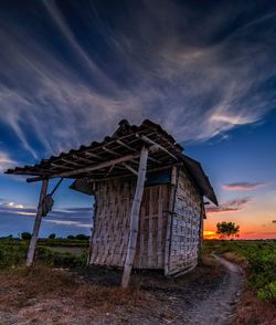 Old abandoned house on field against sky