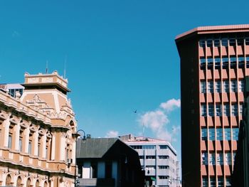 Low angle view of buildings against blue sky