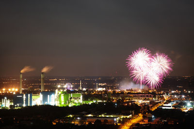 Firework display over illuminated city at night