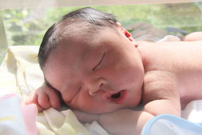 Close-up of cute baby boys sleeping on bed