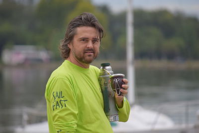 Portrait of man holding bottle and container