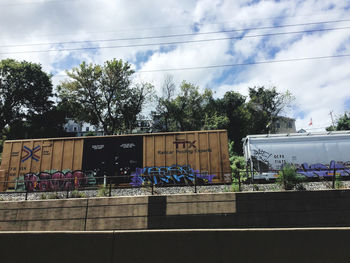 Text on railing against sky in city