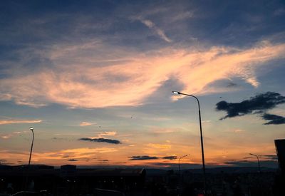 Silhouette street light against sky at sunset