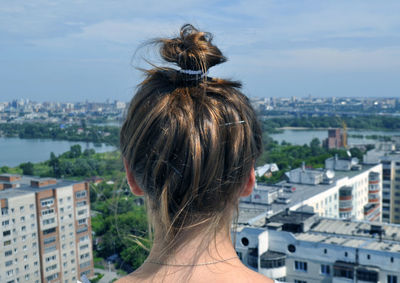 Rear view of woman standing against buildings