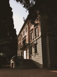 Building by trees against sky