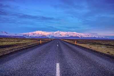 Road amidst landscape against blue sky