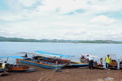 People sitting on beach against sky