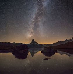 Scenic view of lake against sky at night