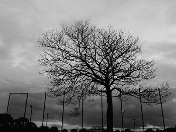 Low angle view of bare tree against cloudy sky