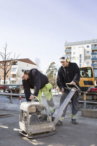 Workers operating machinery at construction site