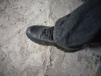 Low section of man standing on sand