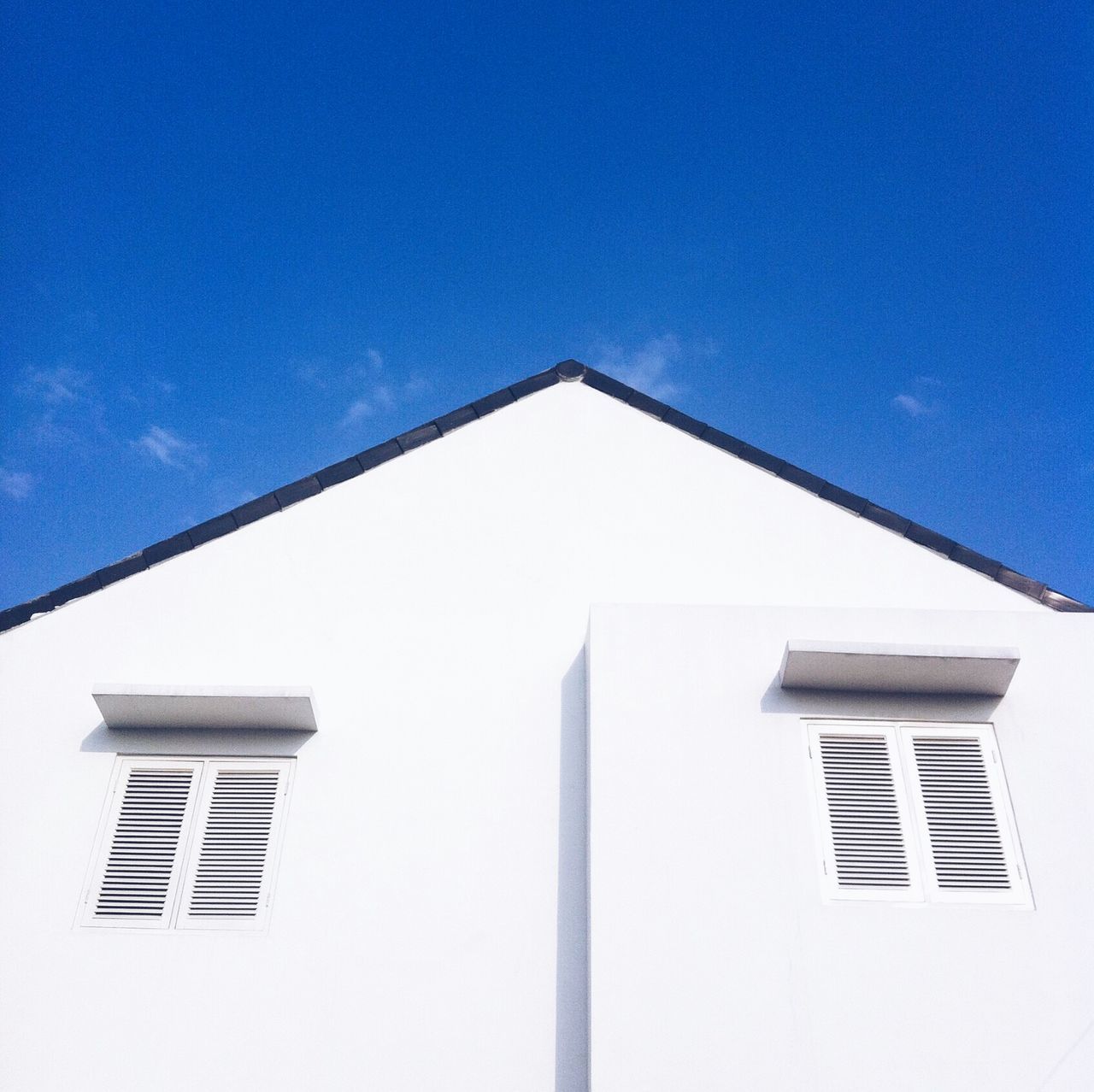 architecture, low angle view, built structure, building exterior, blue, clear sky, window, building, high section, copy space, sky, day, outdoors, no people, city, sunlight, residential structure, residential building, tower, part of