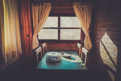 Sunlight streaming through window over table and chairs in room