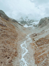 Scenic view of road by mountains against sky