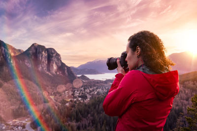 Woman photographing at sunset