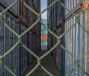 Containers viewed through a chainlink fence