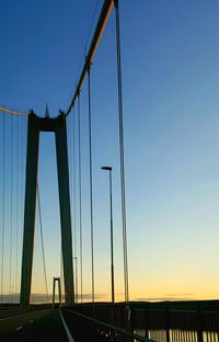 Suspension bridge against clear sky during sunset