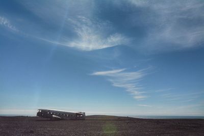 Road amidst field against sky